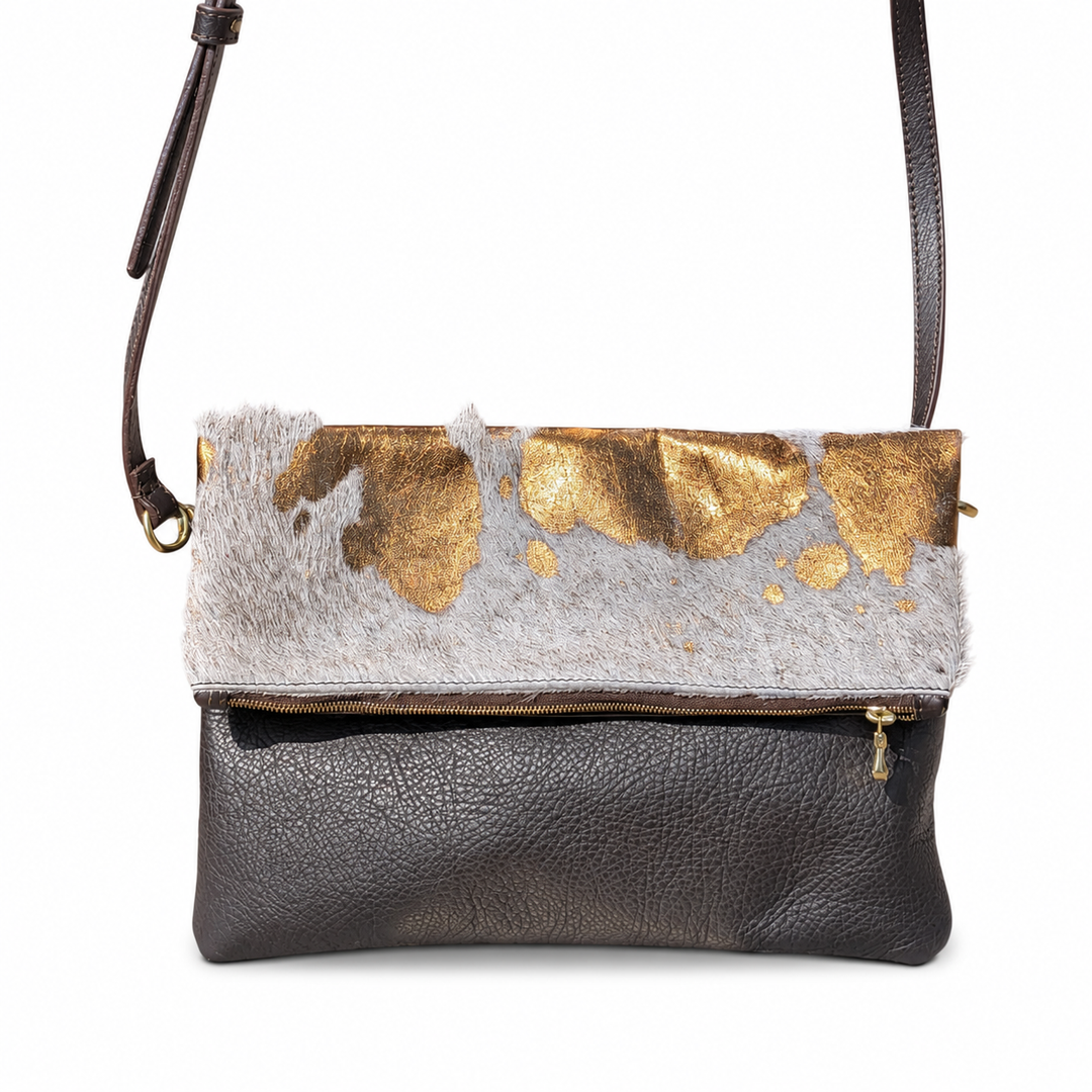 Stowfold bag with white-and-gold hide flap and extended shoulder strap