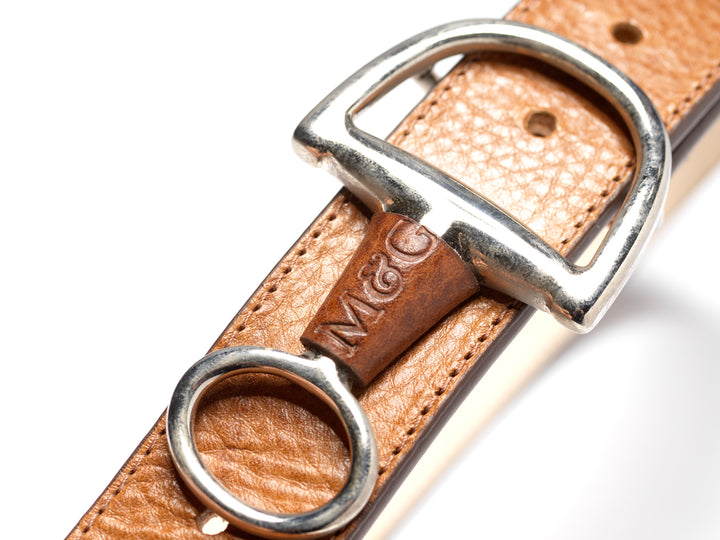 Close-up of a tan Windsor belt with silver-tone fittings