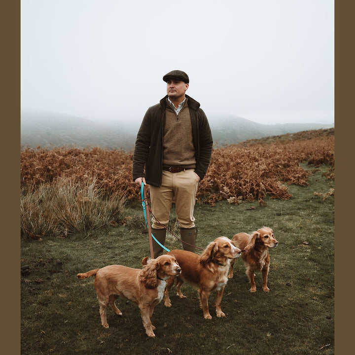 Handler standing with three spaniels on Biothane leads