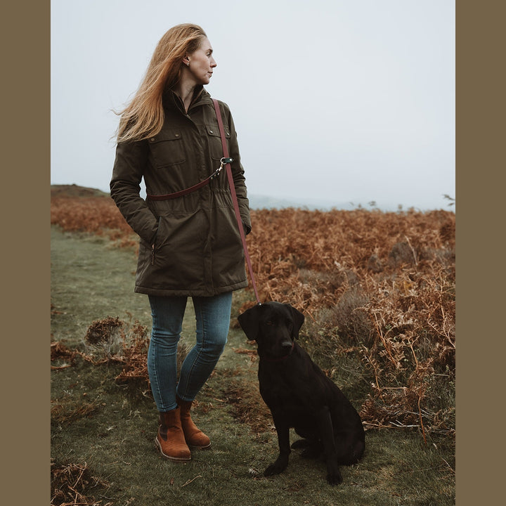 Handler with a black Labrador and shoulder-worn Biothane multi-way lead