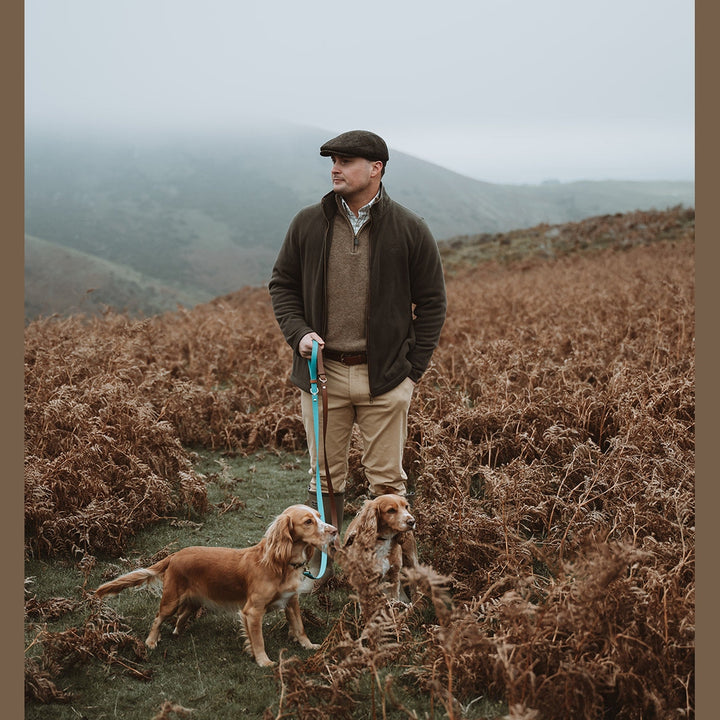 Handler and spaniels with Biothane leads on a moorland path