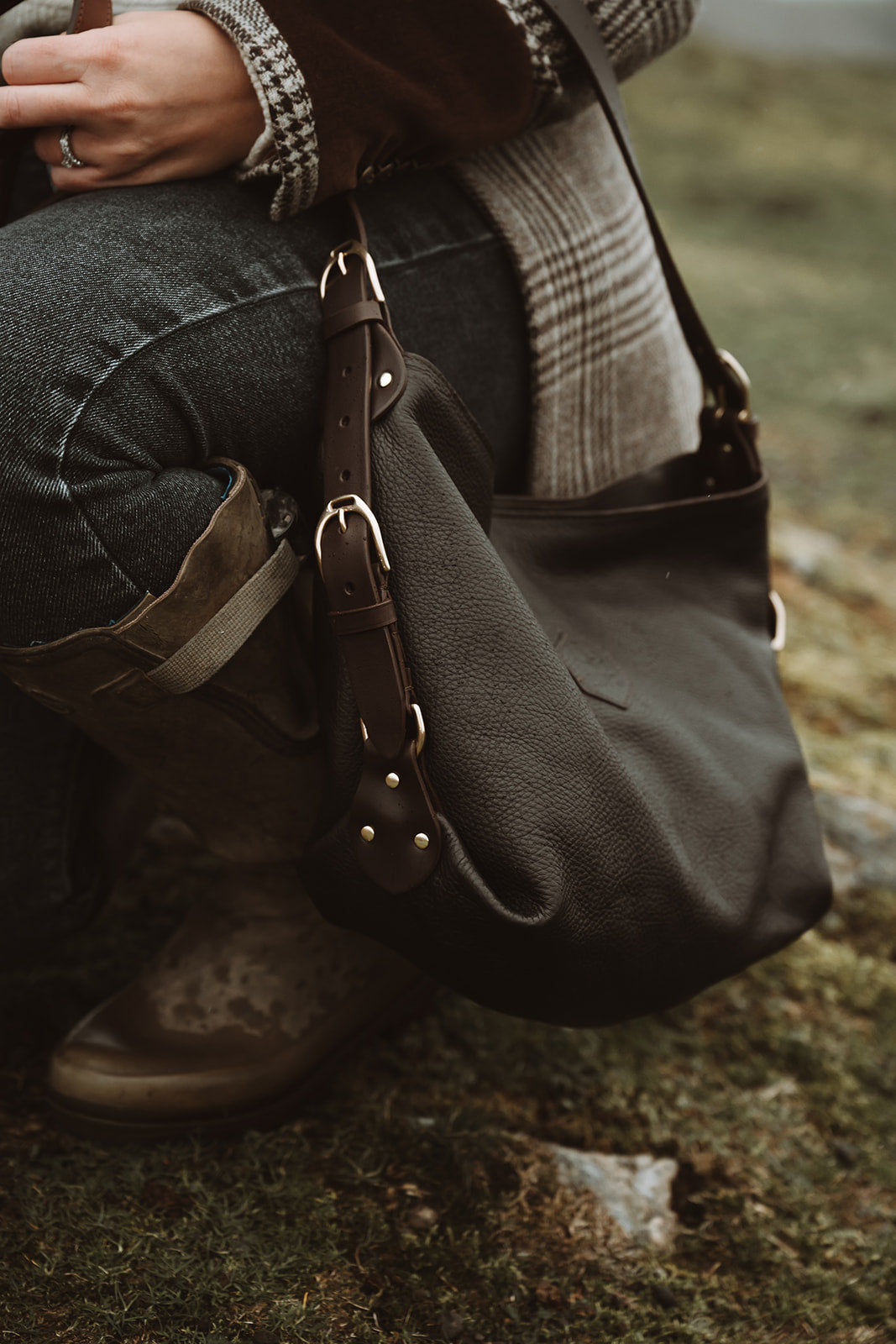 Dark Clifton Tote bag carried beside a checked coat
