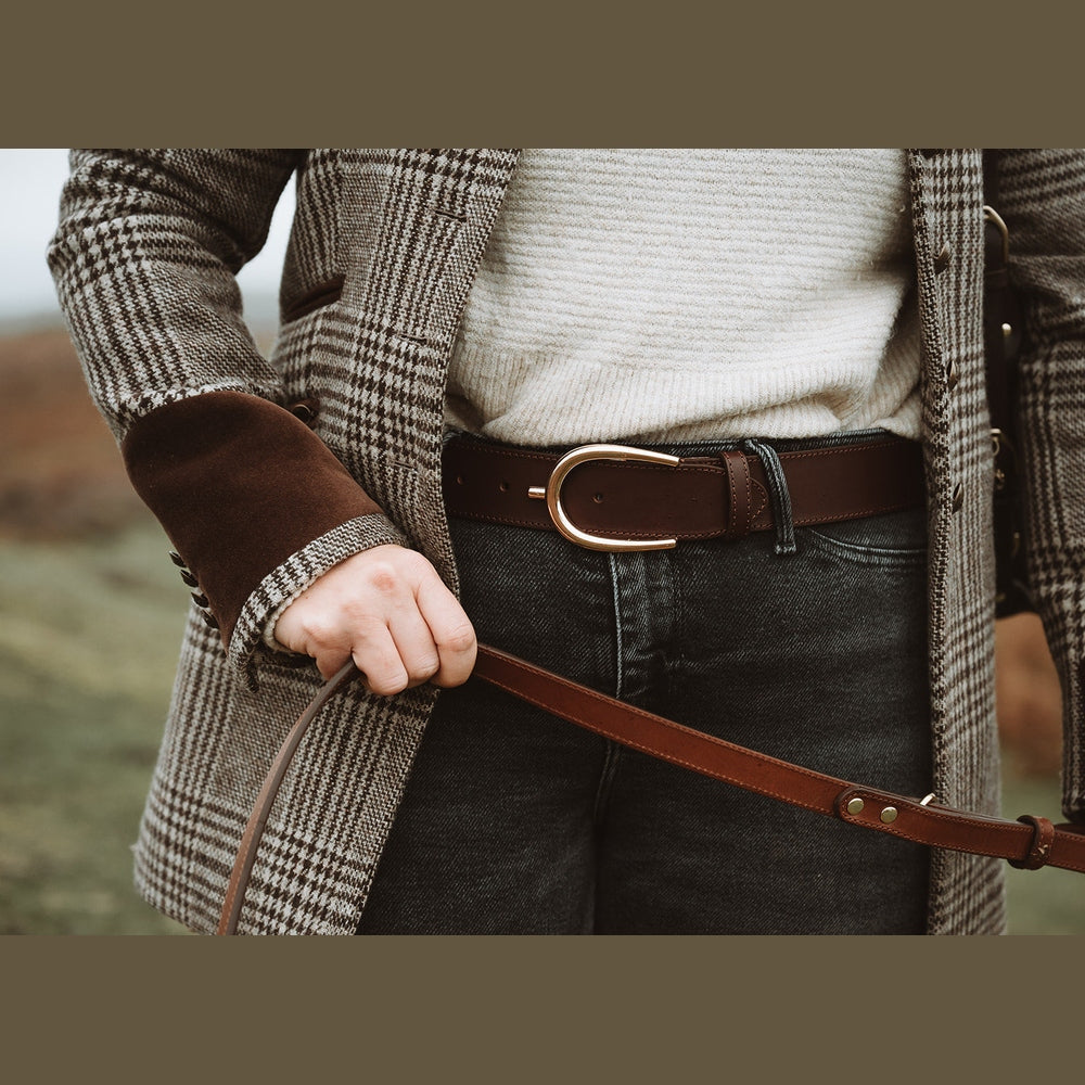 Brown leather lead held beside a checked coat