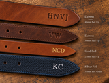 Four belt tips showing plain debossed initials, gold foil initials and silver foil initials