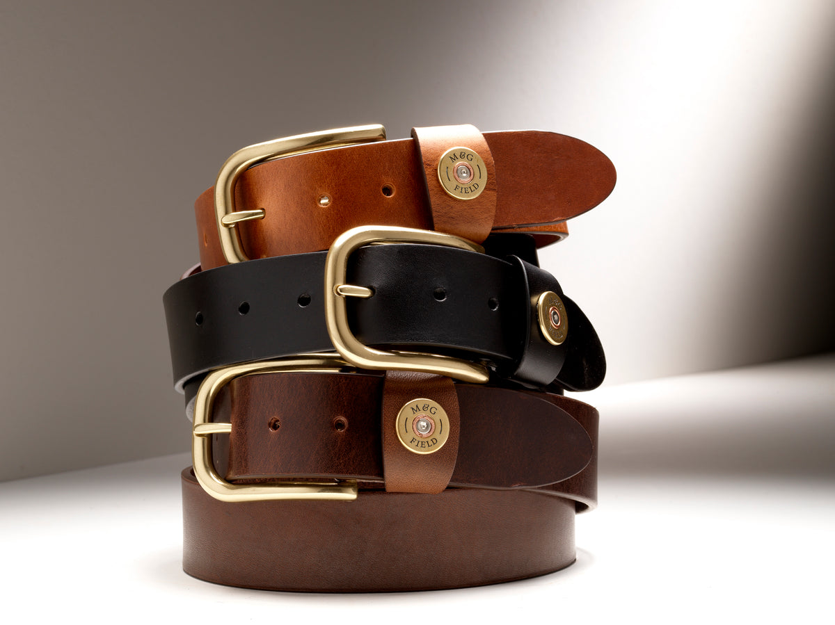 Three Wycombe belts in Chestnut, Black and Chocolate stacked with brass buckles and cartridge keepers visible